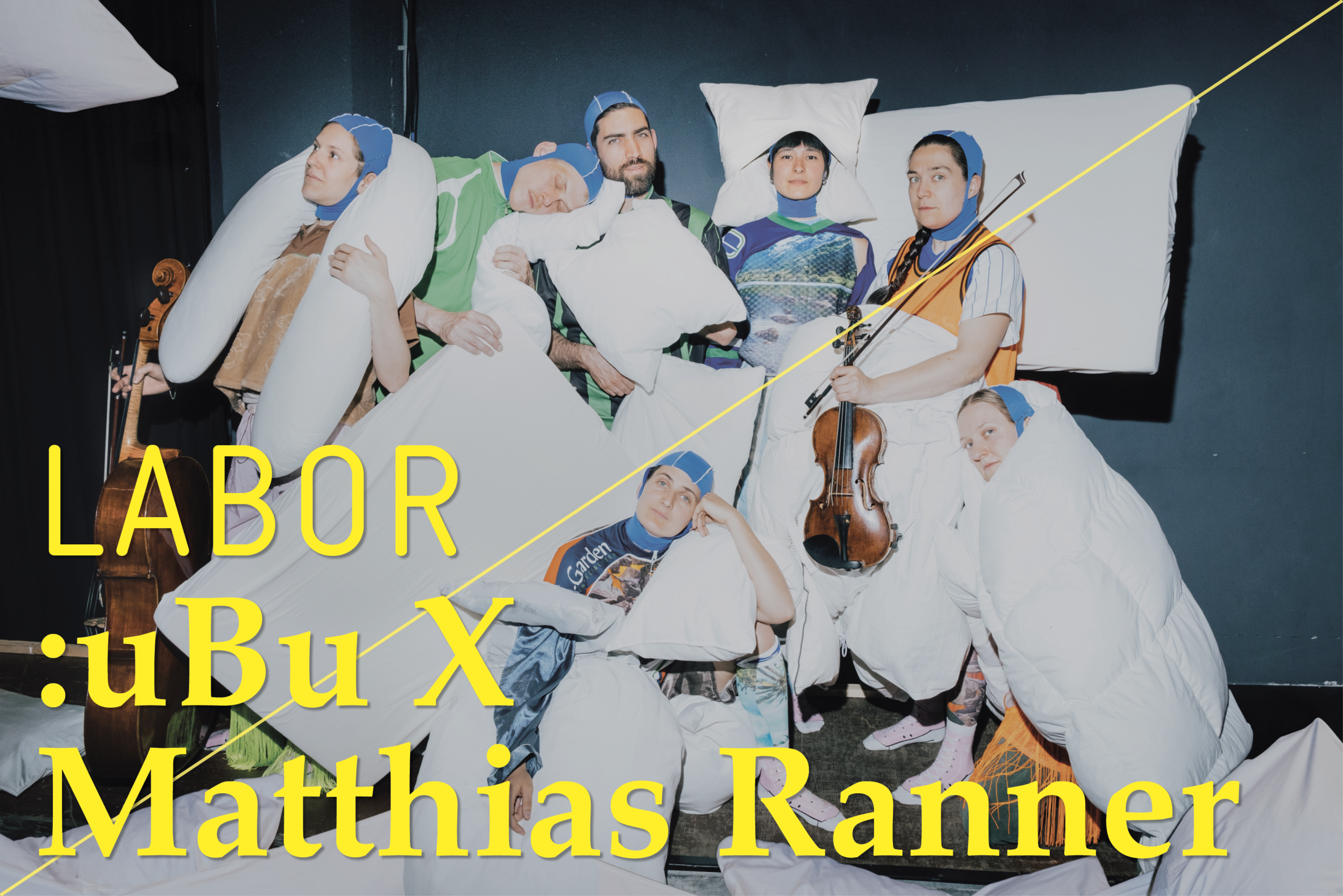 Sieben Personen mit Kissen und Alltagskleidung posieren auf einer Bühne, eine Person hält eine Geige, gelbe Schrift mit den Worten 'LABOR :uBu X Matthias Ranner' überlagert das Bild.